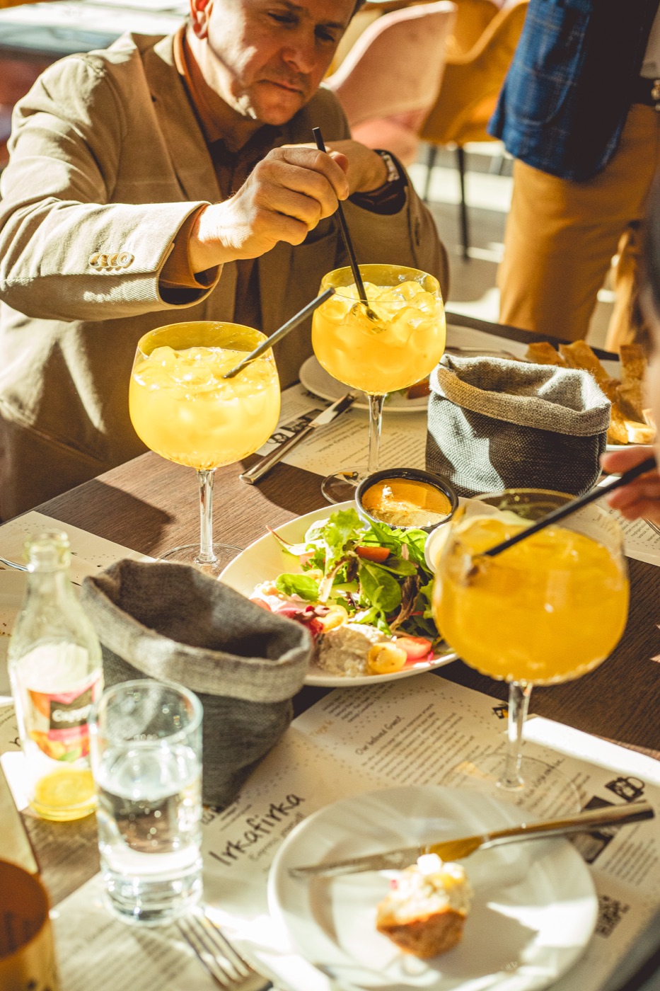 Vendégek a VakVarju Budán Compact Cocktailt fogyasztanak az asztalnál
